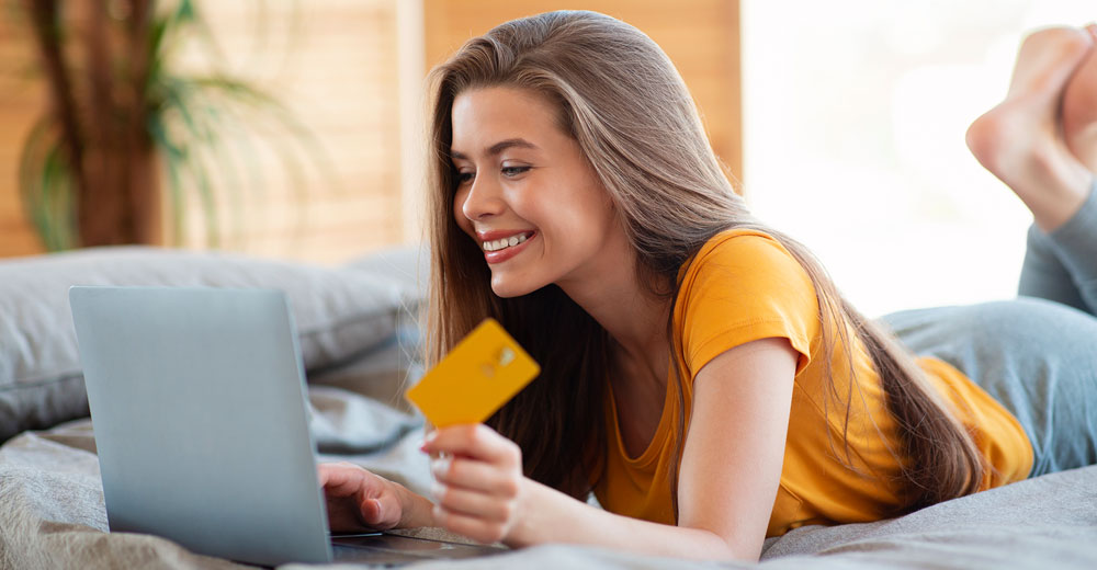 young lady with laptop and credit card online shopping